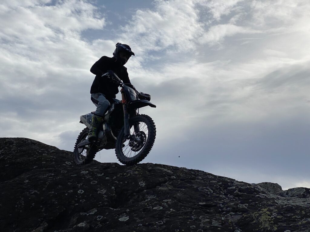 Backlit picture of an enduro bike on a boulder